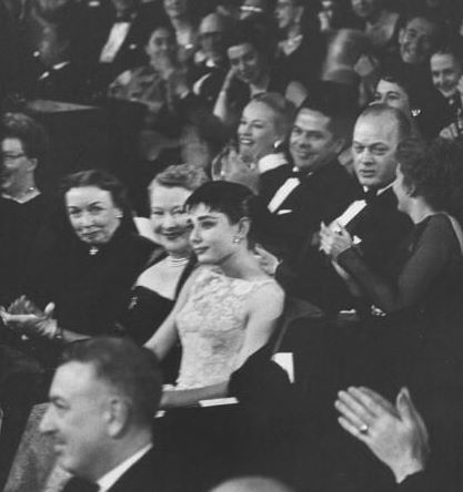 March 25th, 1954, the oscar night. Near tears after her name was called as the winner, Audrey sits for a moment as the audience applauds her.