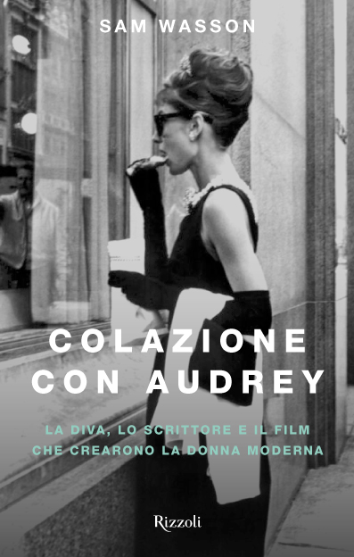 colazione con audrey eating a croissant watching a shop window wearing a black dress, gloves and sunglasses
