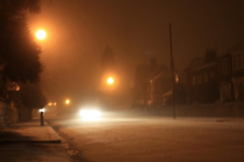Autumn evening with street lamps light on icey road