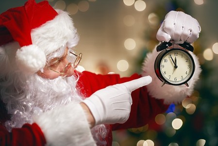 Portrait of Santa Claus with alarm clock in hand