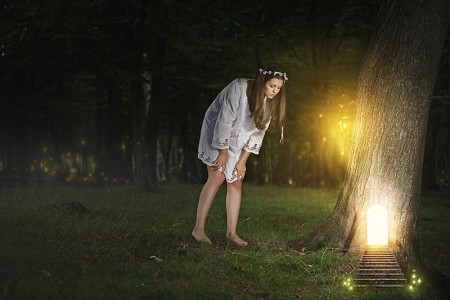 Beautiful young woman finds the door to fairy realm . Fantasy concept