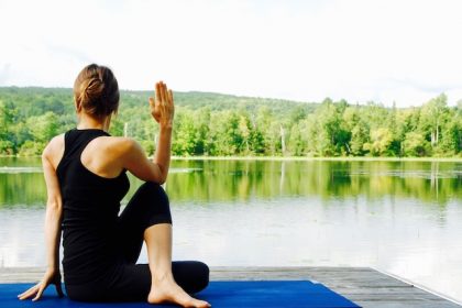 woman doing yoga by the lake