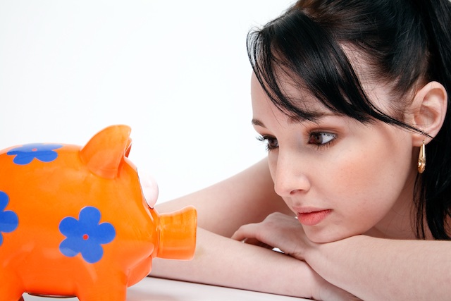 woman looking at money piggy-bank