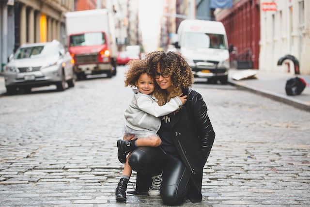 single mum hugging her daughter in the middle of the road