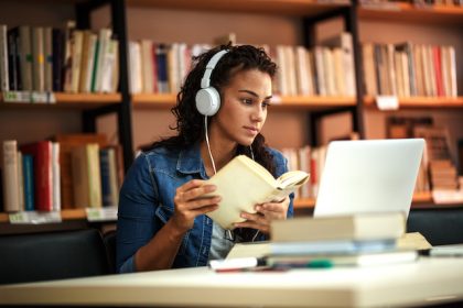 Young female student study in the school library.She using laptop and learning online.