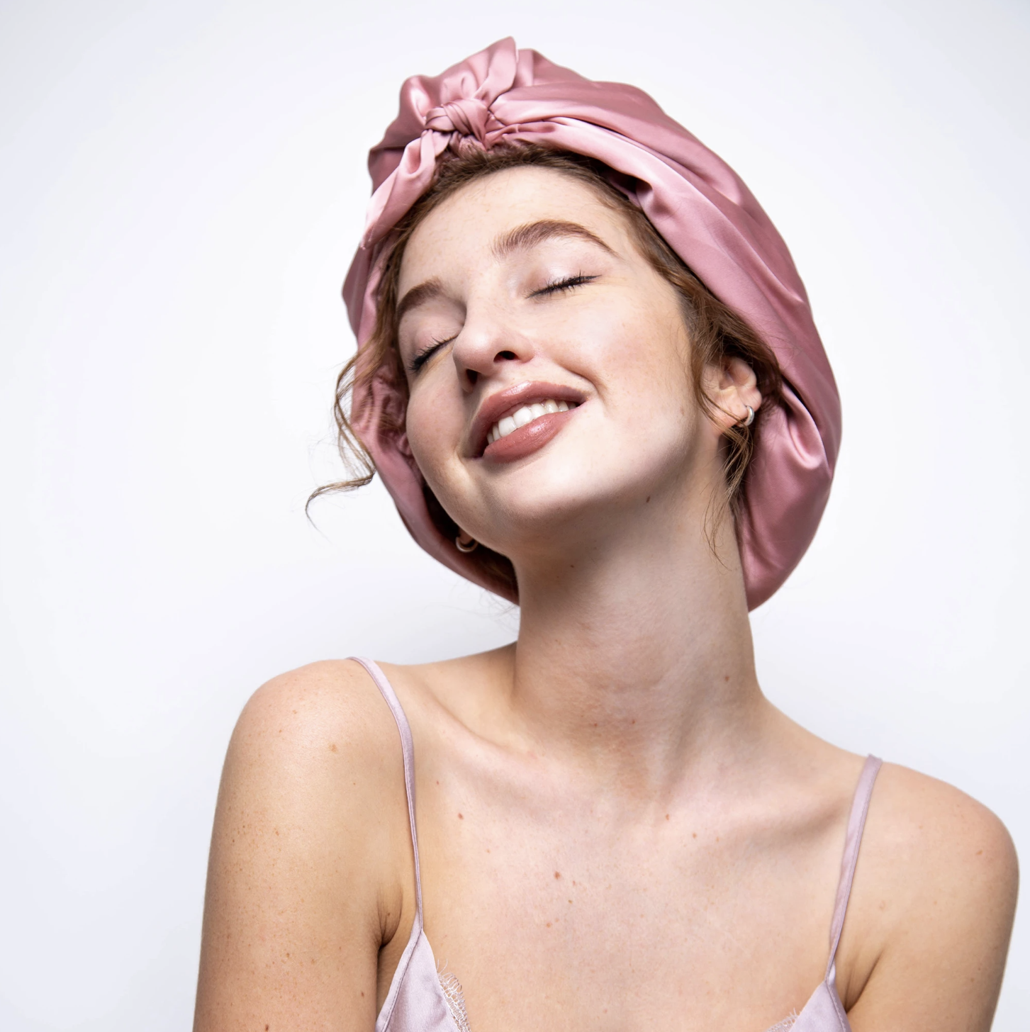 woman wearing a pink hair towel smiling and posing for mums magazine