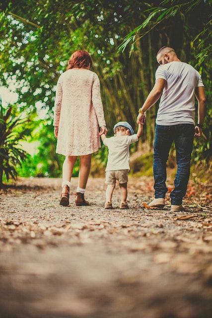 parents and child walking in FOREST