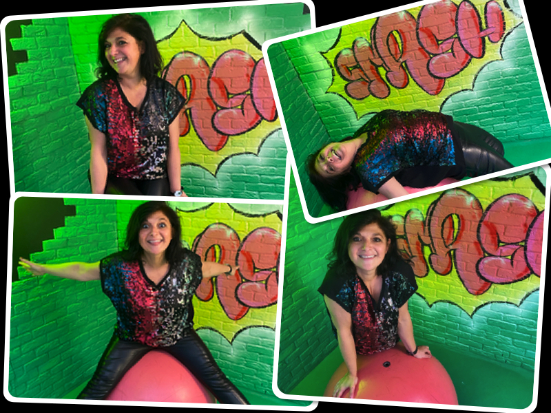 Woman wearing a red and green top on gum ball with green backdrop at dopamine land in Kensington london posing for mums magazine