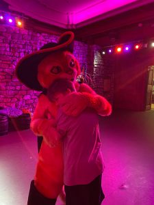 teenage boy posing with giant cat puppet puss in boots in London for mums magazine