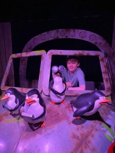 teenage boy posing with penguin puppets in London for mums magazine