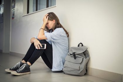 teenager girl sitting down desperate and worried