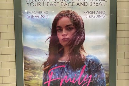 Movie poster on London Tube showing woman wearing Victorian dress posing for camera