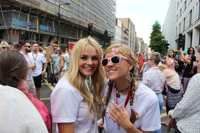 two women lesbians wearing white shirts at LGBT parade posing for mums magazine