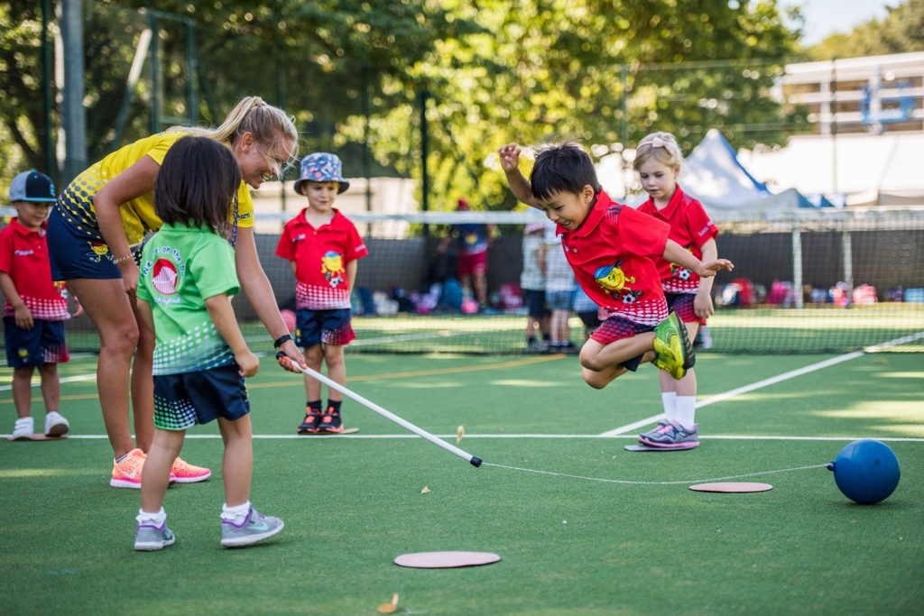 toddler children wearing red shirt play with sport teacher 