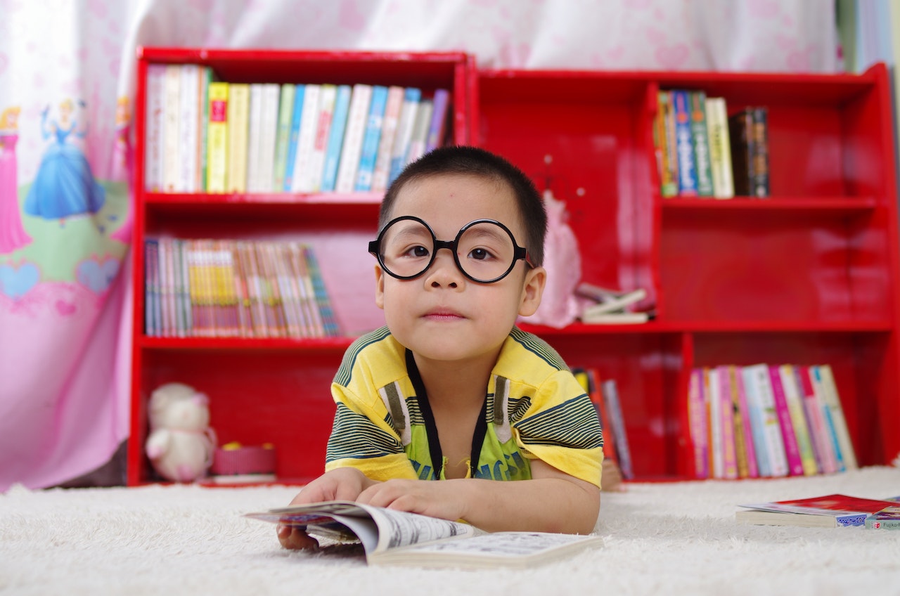 young boy in glasses reading