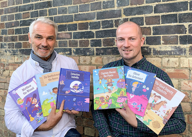 two dads hold personalised books posing for mums magazine