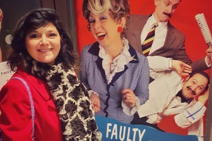 monica costa wearing a red coat at West end for review of The Faulty Towers Dining experience