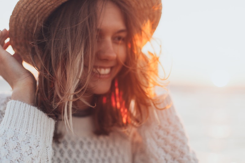 woman laughing wearing a hat posing for mums magazine