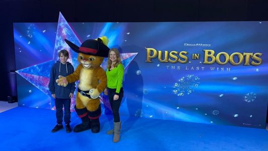 Alec and mum Joanna posing for mums magazine with Puss in Boots at film premiere in London