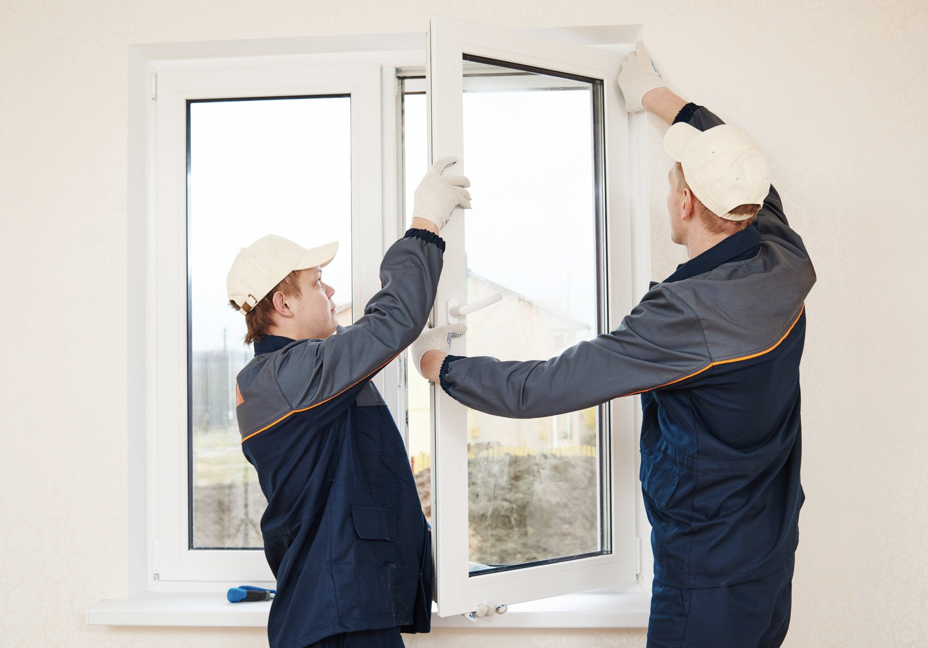 two men replacing double-hung window 