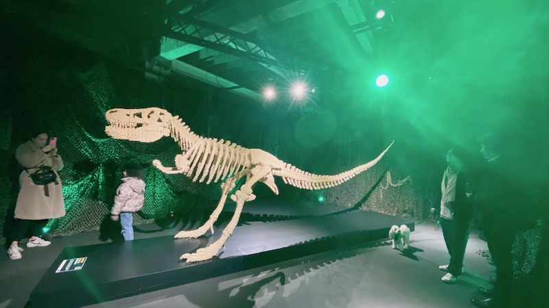 Trex child and dog posing at art of the brick expo london 2024