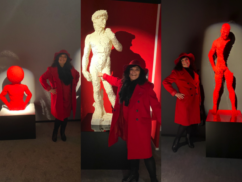 monica costa wearing a full red outfit posing at LEGO art expo Art of the Brick in London