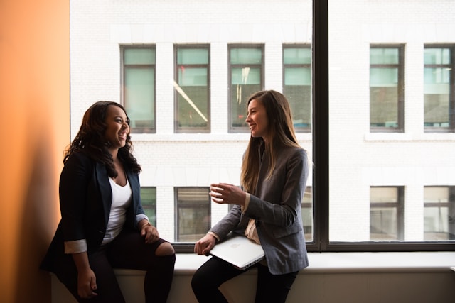 two women sitting at window 