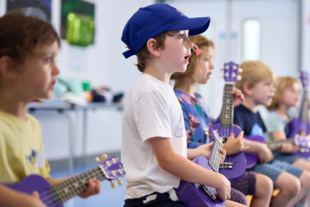 The strings club kids playing ukulele