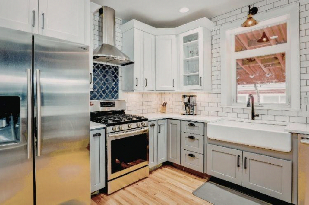 Kitchen with stainless steel range hood and white cabinets