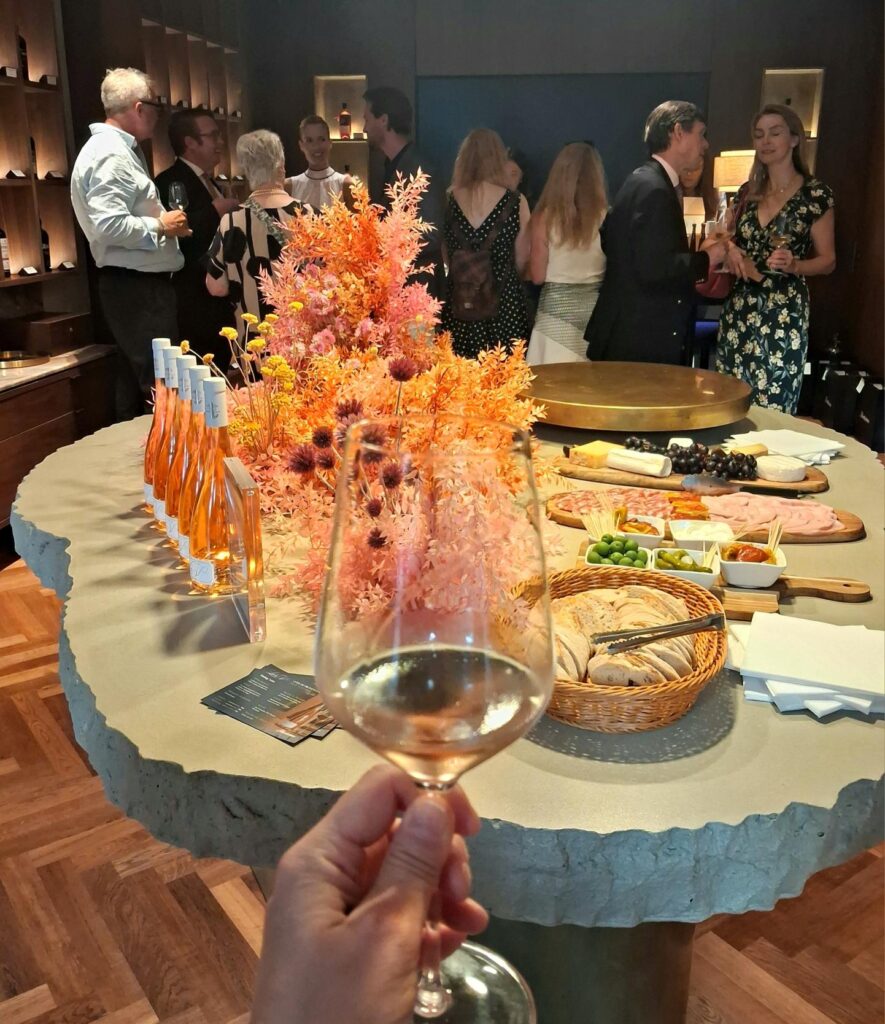 Elegant bottle of Lala V Côtes de Provence Rosé at its exclusive launch party at Hackstons in Knightsbridge, surrounded by wine glasses and a glamorous event setting.