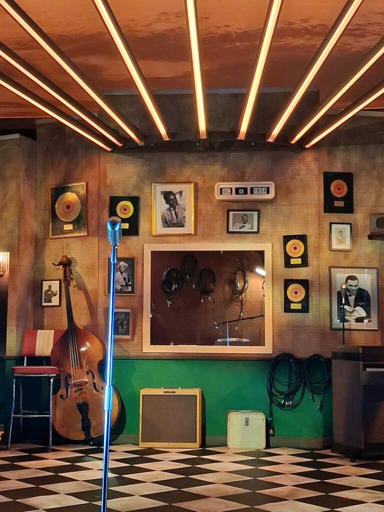 1950s-style recording studio stage for Million Dollar Quartet, with vintage microphone, music awards and musical equipment