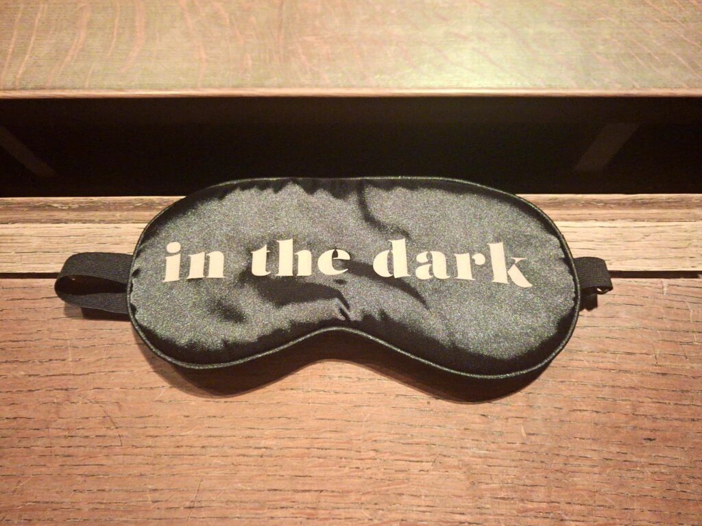 Sleeping mask resting on a wooden bench inside St Bartholomew’s Church for the In The Dark concert